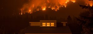 Forest fire behind a house