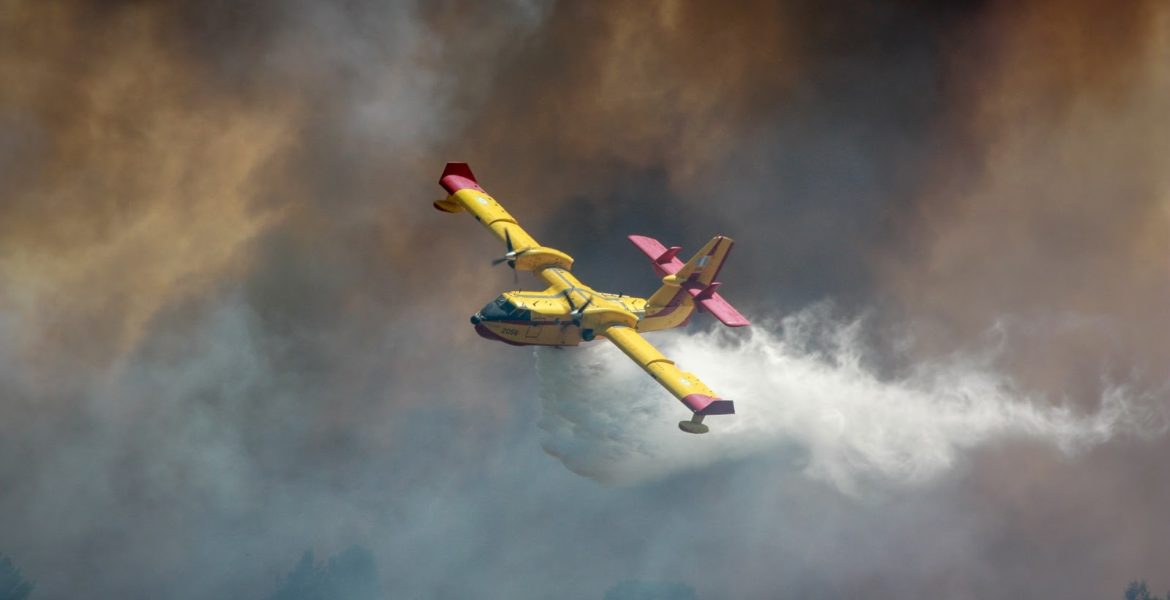 fire suppression plane flying through thick smoke.