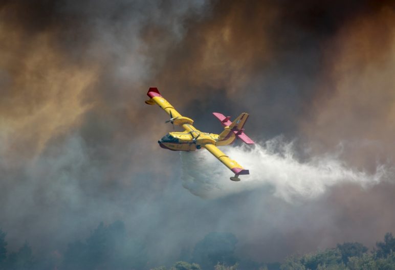 fire suppression plane flying through thick smoke.